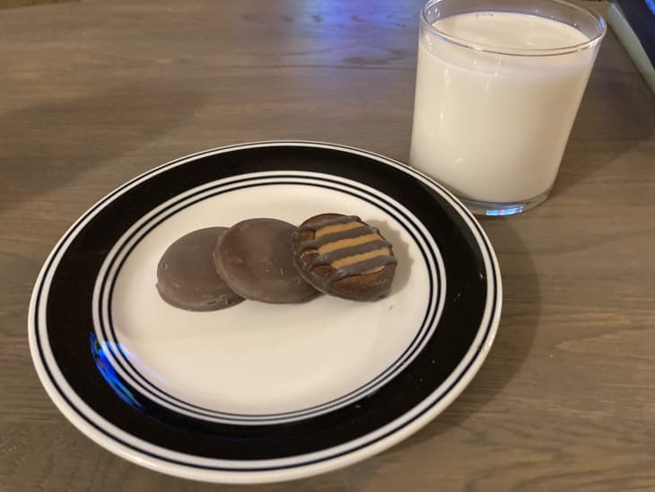 3 Girl Scout cookies on a plate with a glass of milk