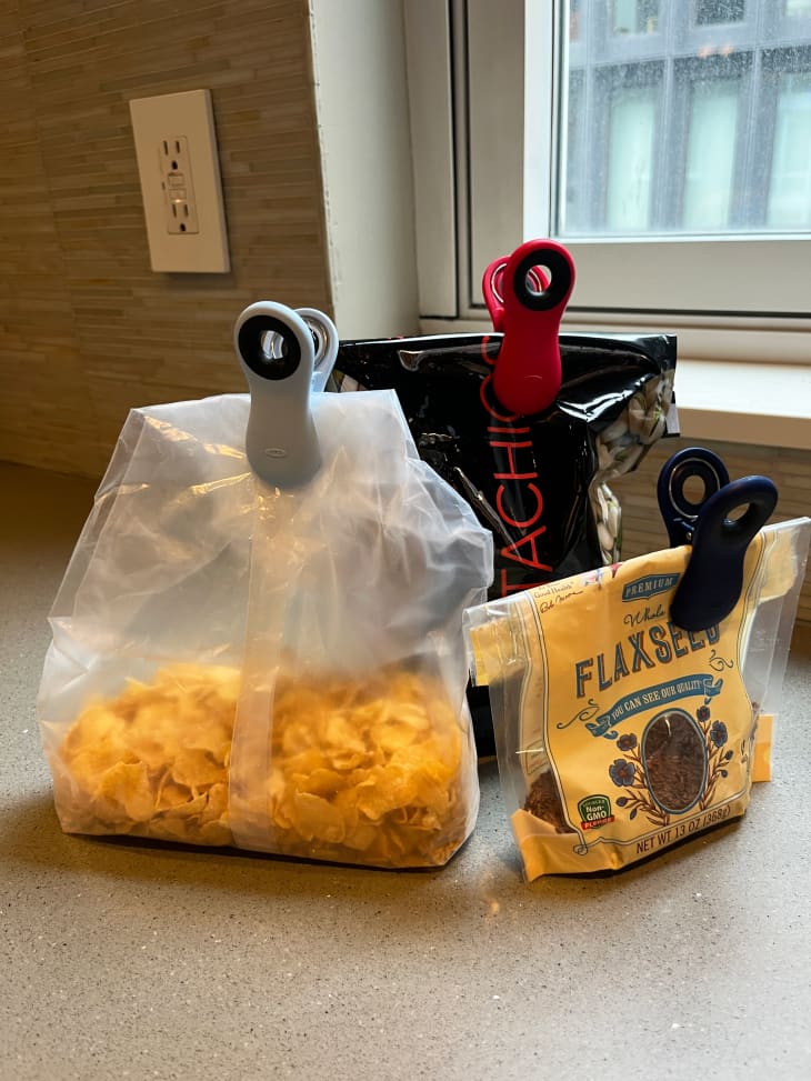 Bags of snacks on kitchen counter clipped with OXO Good Grip bag clips.