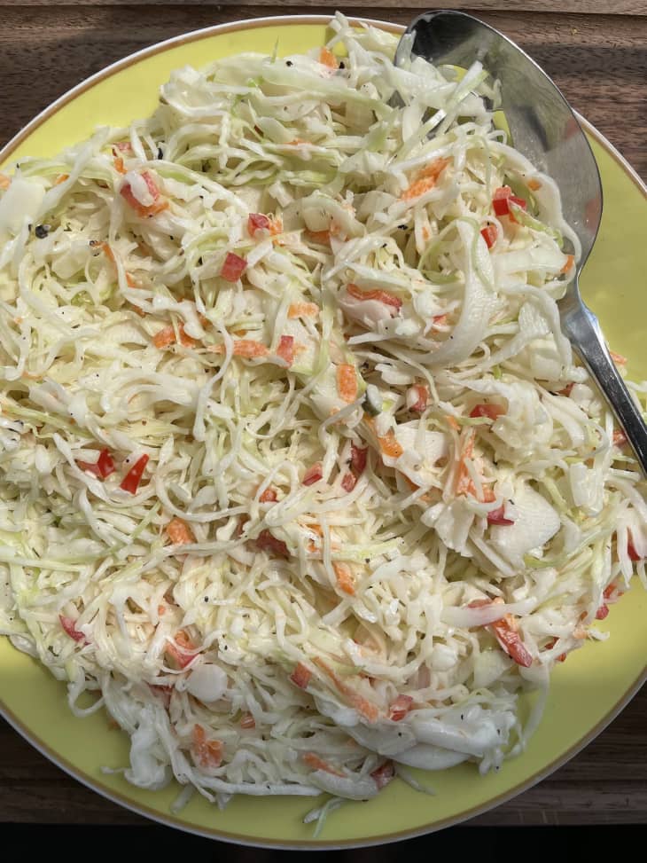 cole slaw with spoon on yellow plate