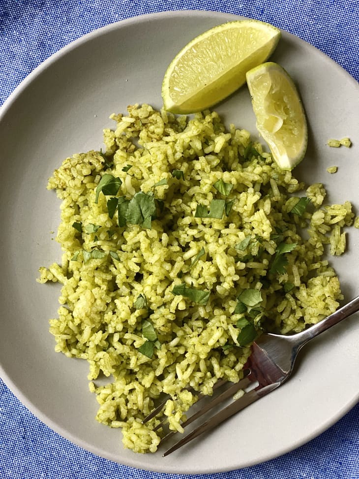 Arroz verde on a plate with lime wedges beside.