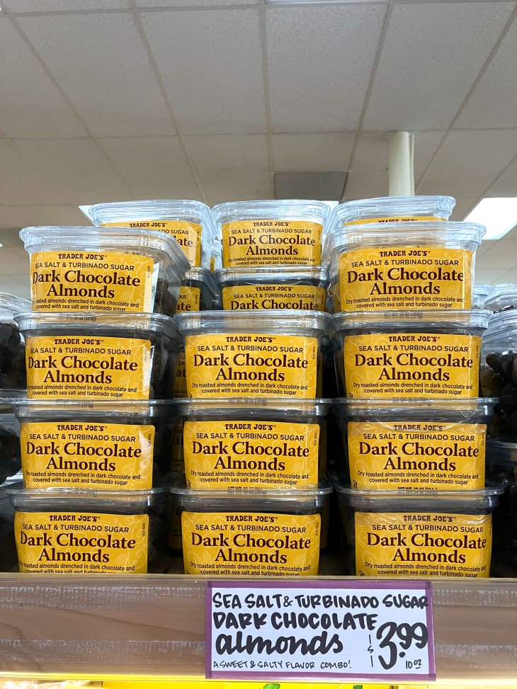 Stacked packaged of Trader Joe's dark chocolate almonds in store.