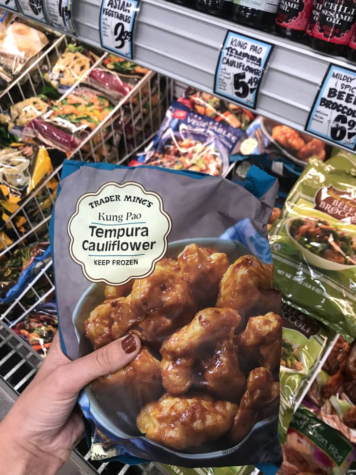 Someone holding package of Trader Joe's Kung Pao Tempura Cauliflower .