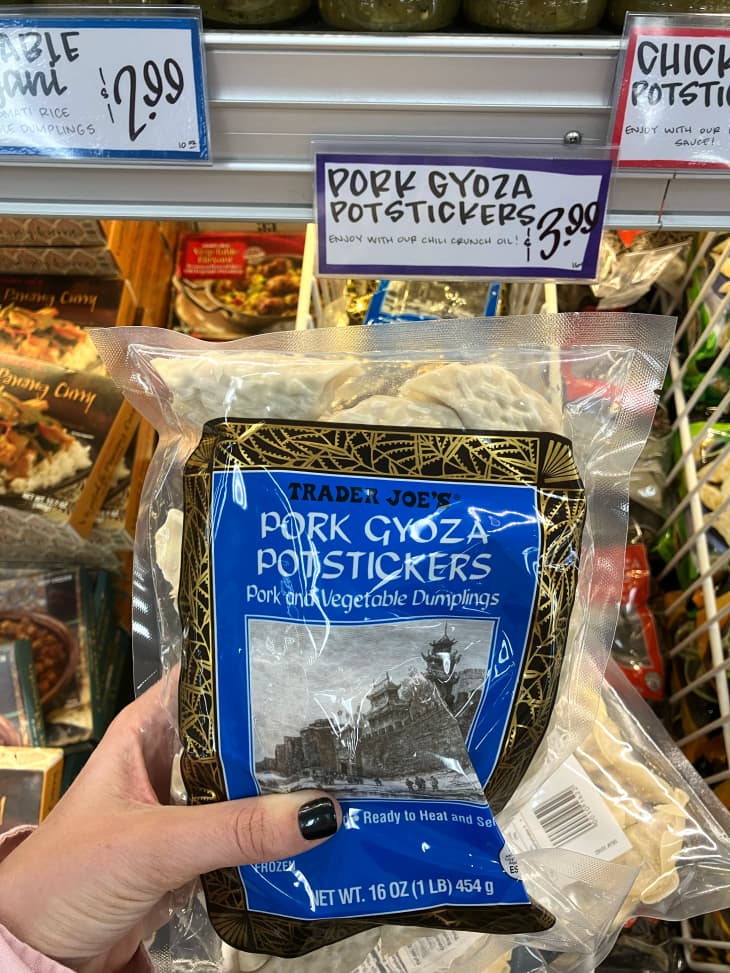 Someone holding package of Trader Joe's goyza potstickers.