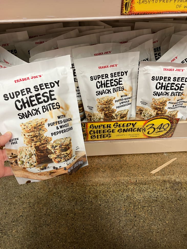Someone holding Trader Joe's Super Seedy Cheese Snack Bites.