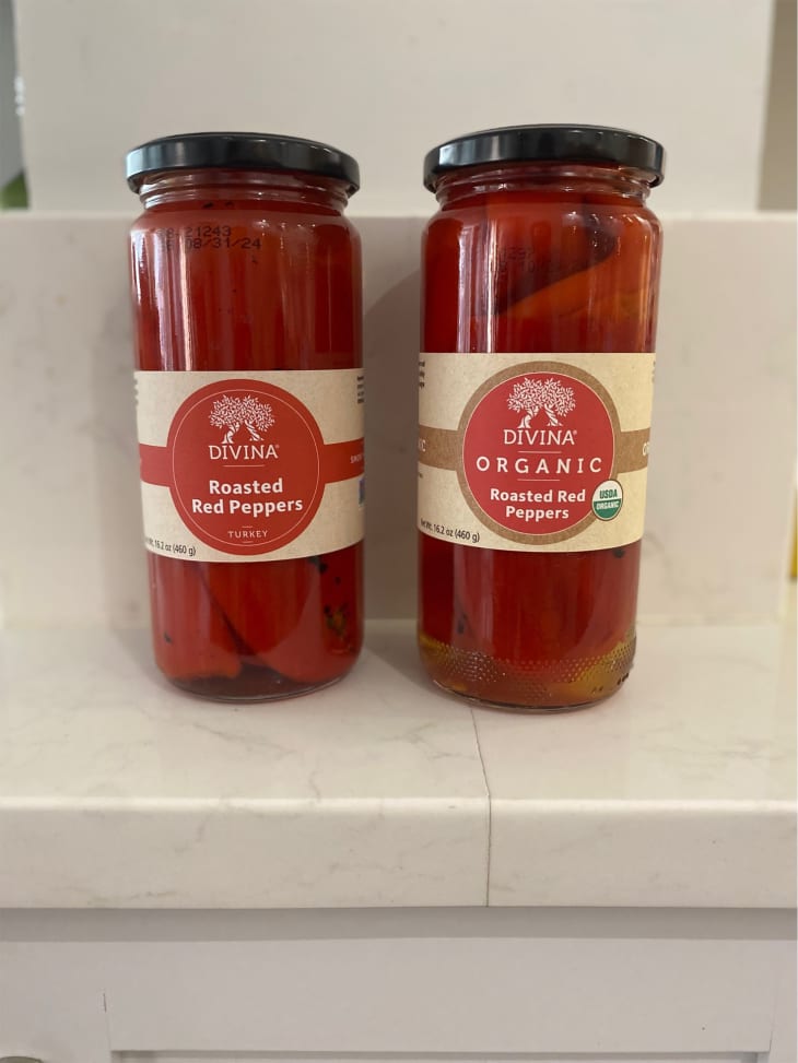 Two jars of Divina roasted red peppers. Jar on left is conventional roasted peppers and on right organic roasted red peppers.