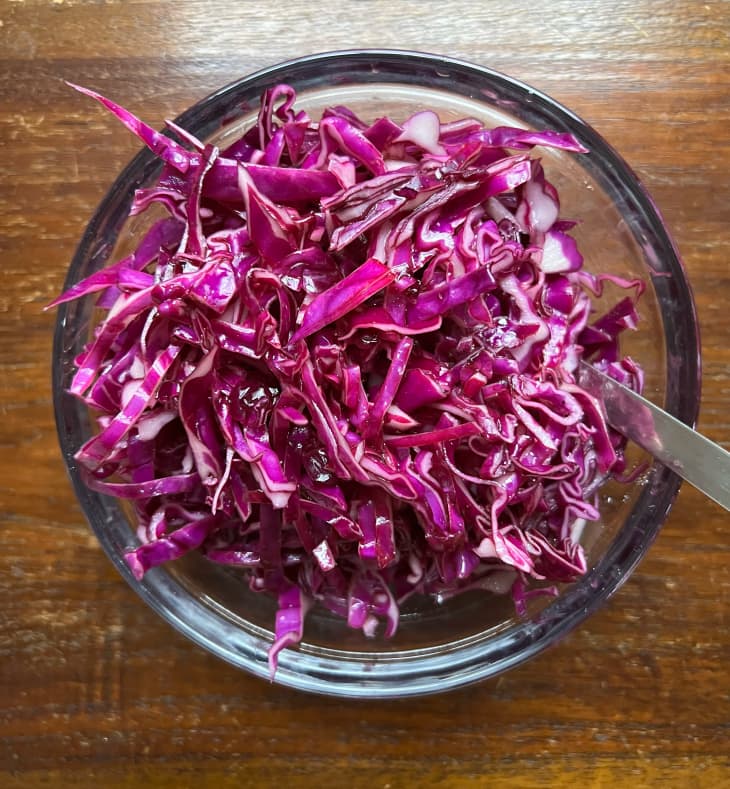 Shredded and sautéed red cabbage in small glass bowl.
