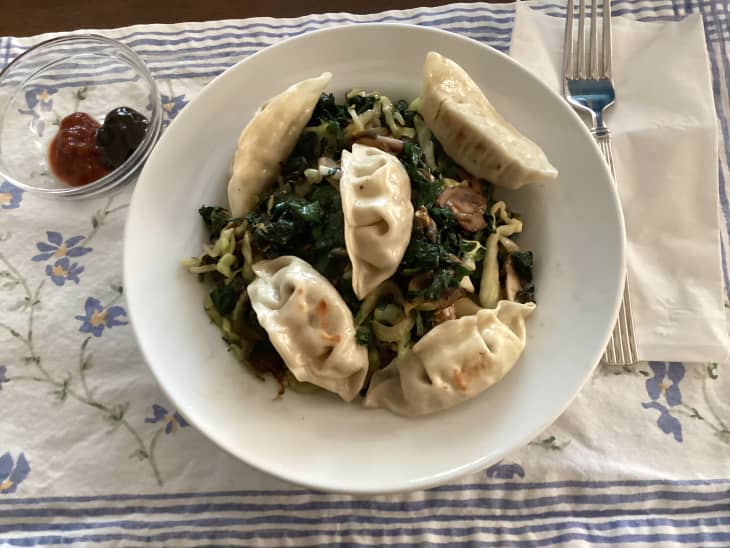 Grocery diary meal: potstickers over greens in shallow bowl