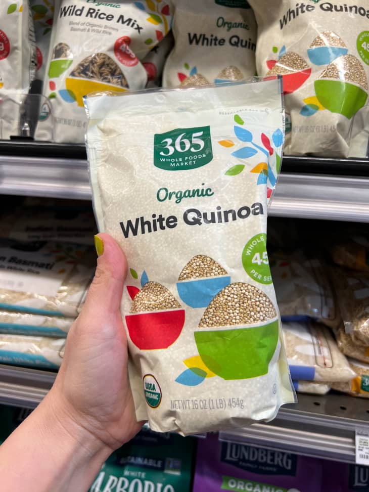 Someone holding 365 brand white quinoa.