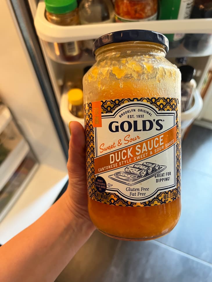 Someone holding container of Gold's duck sauce.