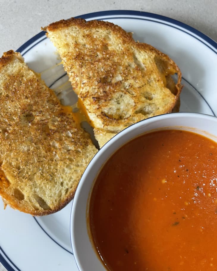 grilled cheese sandwich cut in half with tomato soup