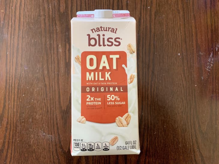 Bliss Oat Milk on wooden surface.