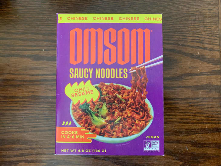 Omsom spicy noodles in package on dining table.