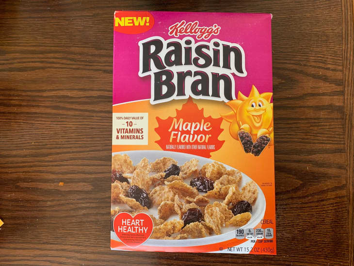 Package of Raisin Bran cereal on wooden surface.