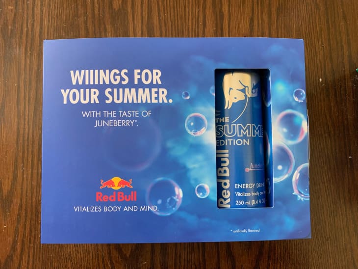 Red Bull energy drink on wooden surface.