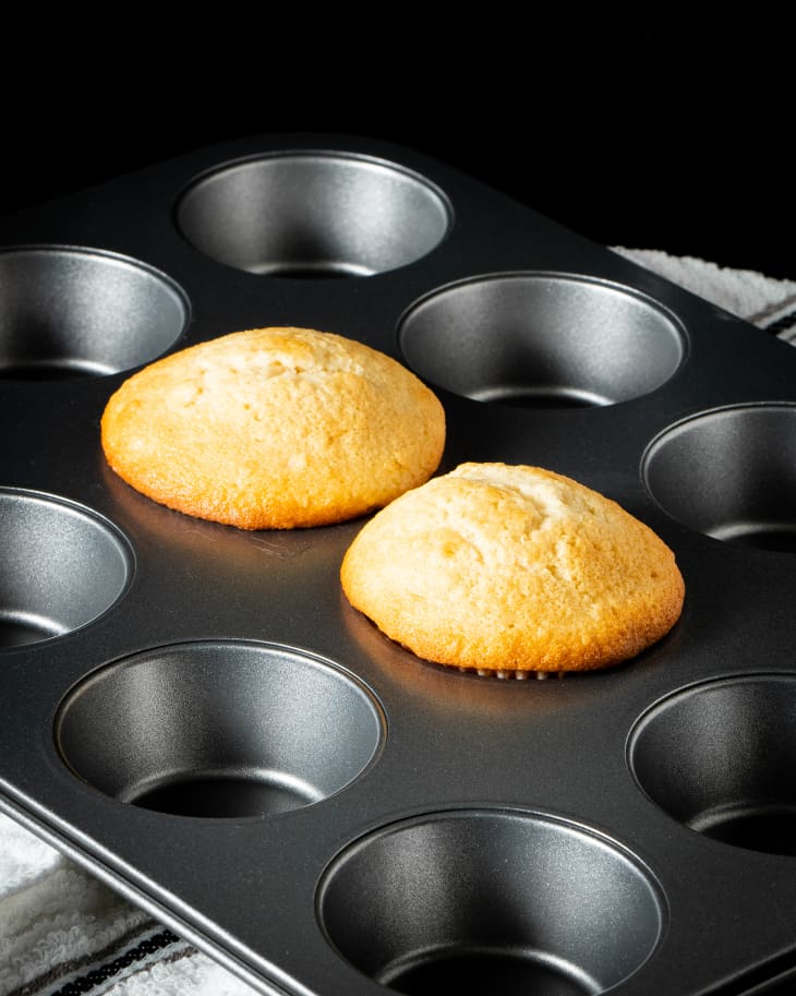 2 vanilla cupcakes after baking, sitting in pan