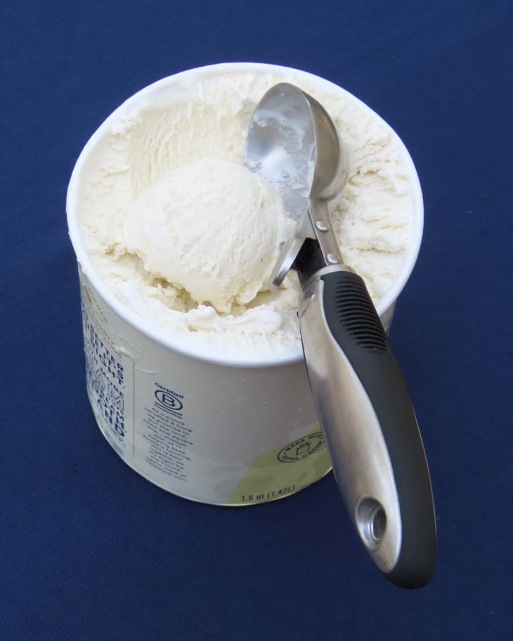 OXO ice cream scoop in a container of vanilla ice cream