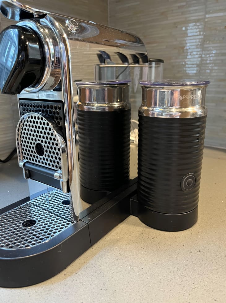 Nespresso Aeroccino3 black Milk Frother sitting on counter next to home espresso machine