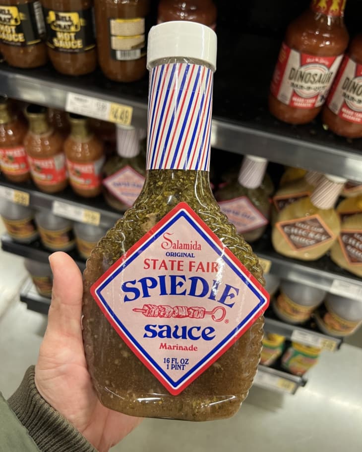 Someone holding up a bottle of Salamida Original State Fair Spiedie Sauce