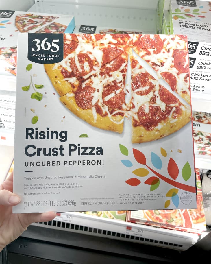 Someone holding up frozen Whole Foods 365 Rising Crust Uncured Pepperoni Pizza in store