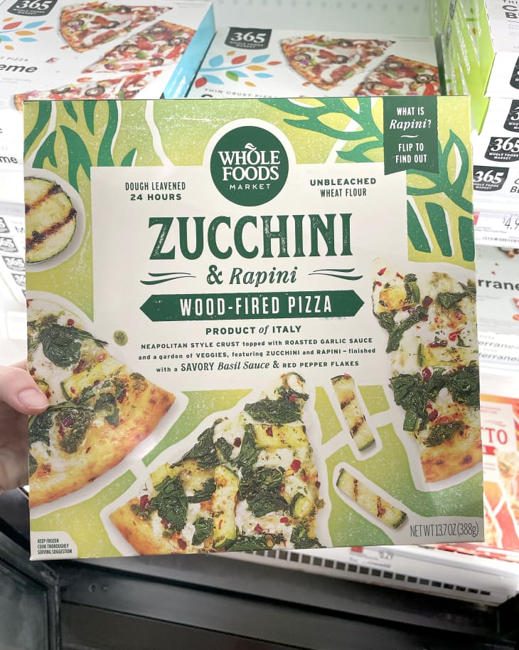 Someone holding up frozen Whole Foods 365 Zucchini &amp; Rapini Wood-Fired Pizza in store