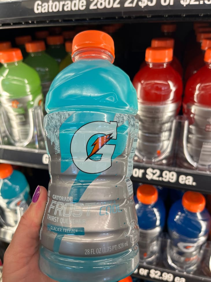 Someone holding gatorade in gas station.