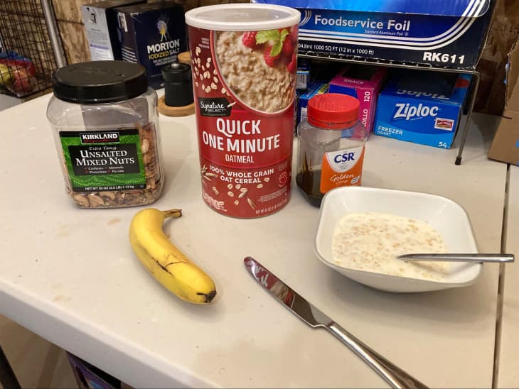 Bowl of oatmeal with ingredients behind.