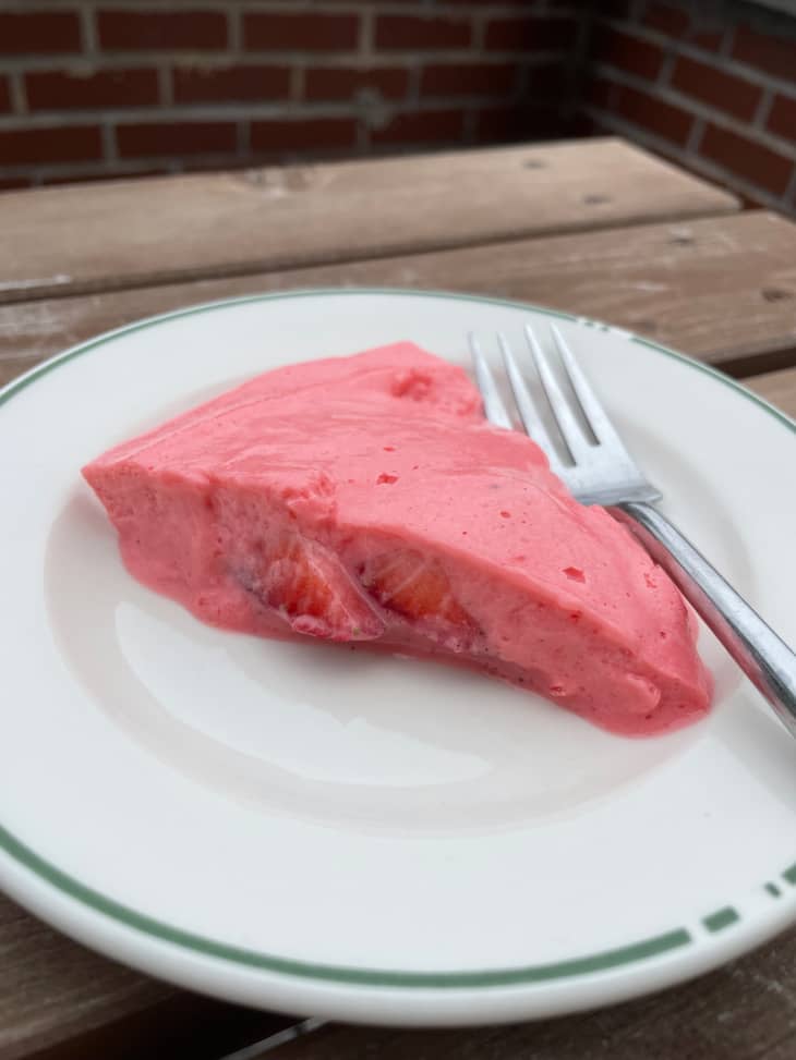 Strawberry nervous pudding on a plate with a fork on the side.
