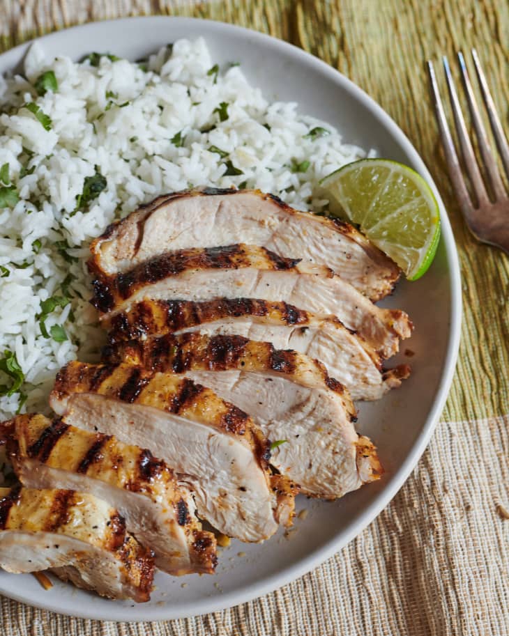 Tequila lime chicken sliced on plate and served with rice.
