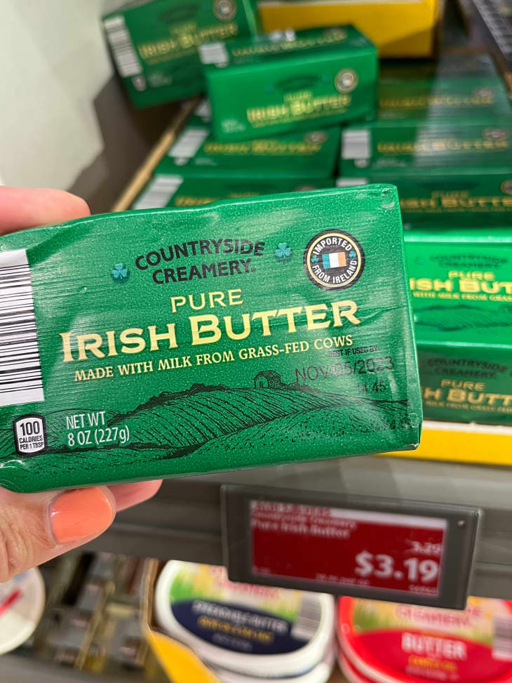 Someone holding Irish butter in store.