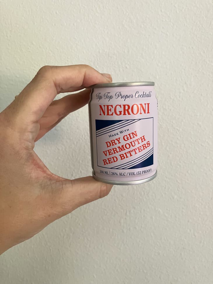 Someone holding small can of Tip Top Proper Cocktails Negroni cocktail.