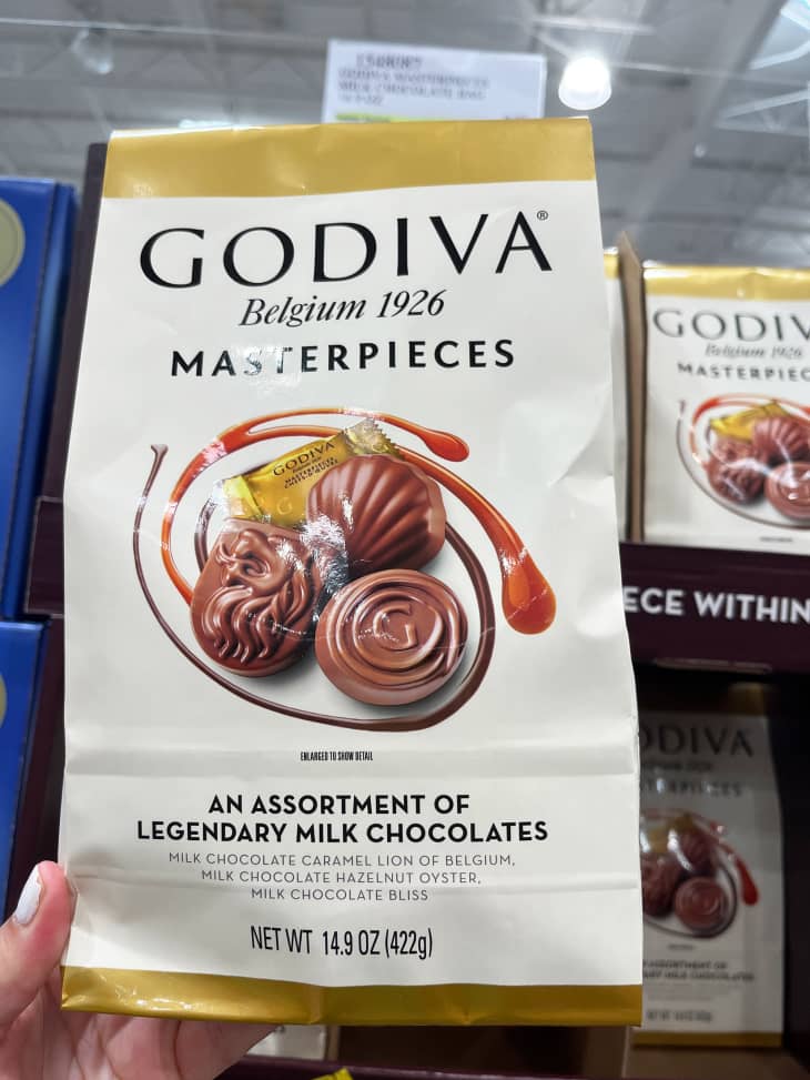 Someone holding up package of Godiva chocolates in Costco.