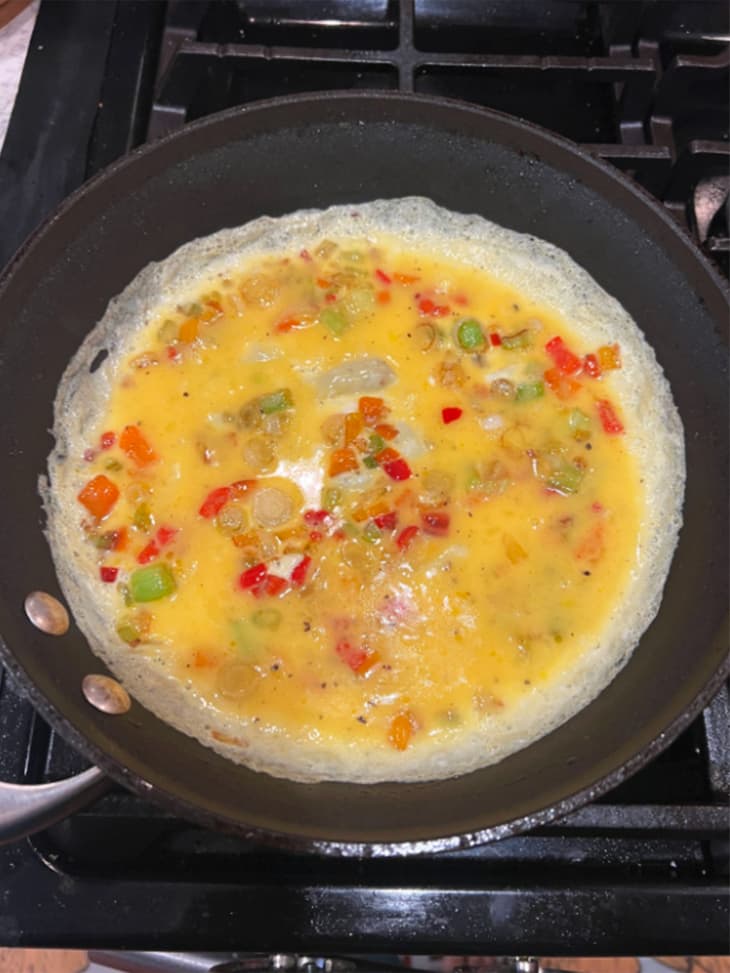 Eggs, meats, cheeses, and peppers melting into a quesadilla