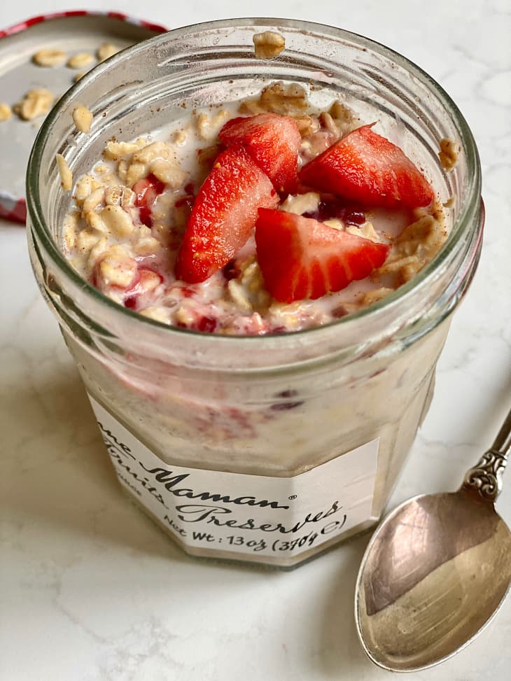 Strawberry slices on top of overnight oats in jam jar.