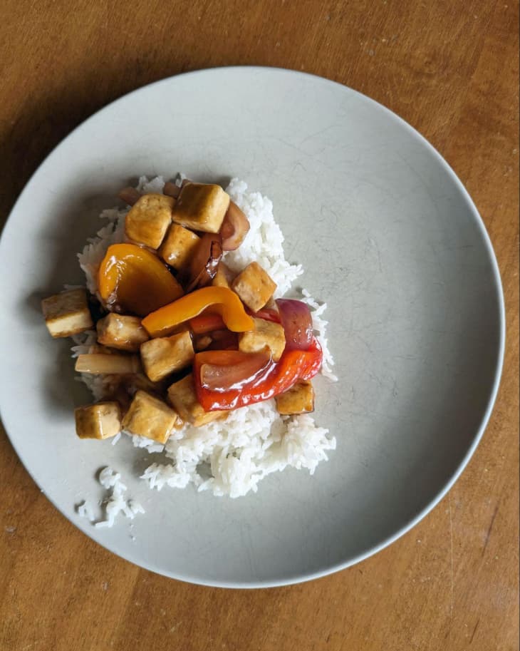 white rice, stir fry peppers, chicken pieces, wood table, grey plate