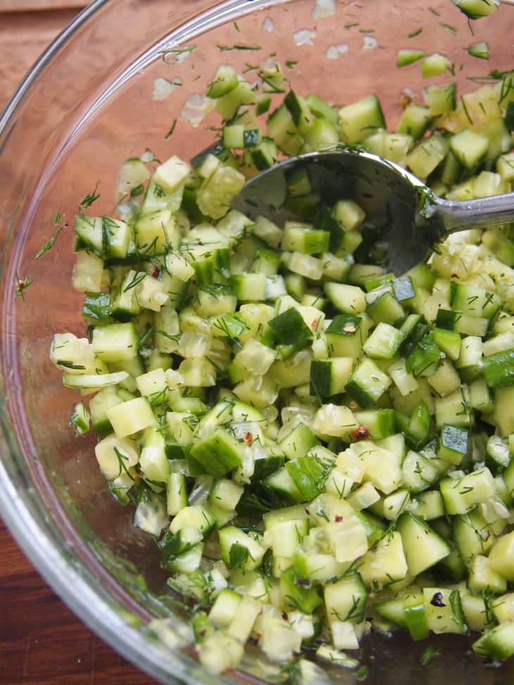 Baked by Melissa's Cucumber Toast recipe: photo of diced cucumber being seasoned in a bowl