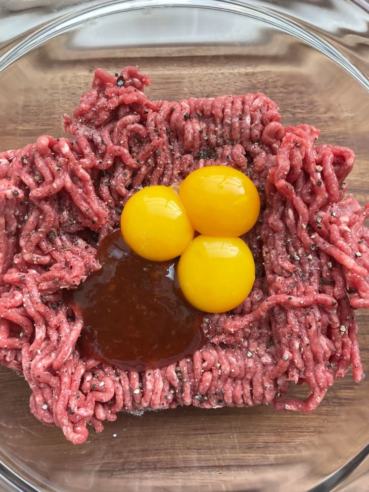 Egg yolks and steak sauce on top of ground beef to make Ina Garten burgers.