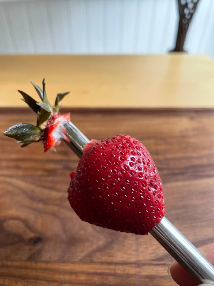 Strawberry being hulled on a reusable straw.
