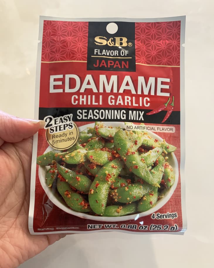 someone holding up a package of edamame chili garlic seasoning