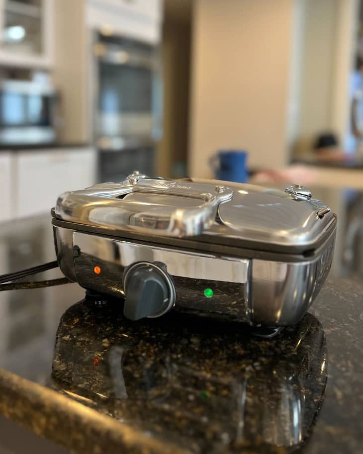 All Clad waffle maker on kitchen countertop.