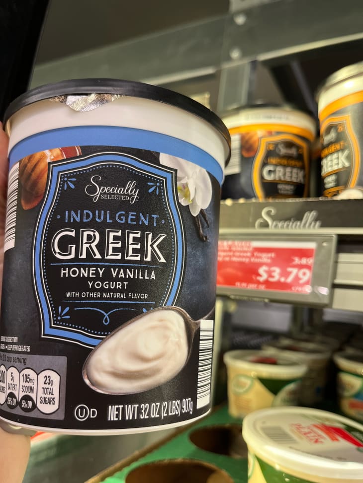 Someone holding carton of Honey Vanilla Greek yogurt.