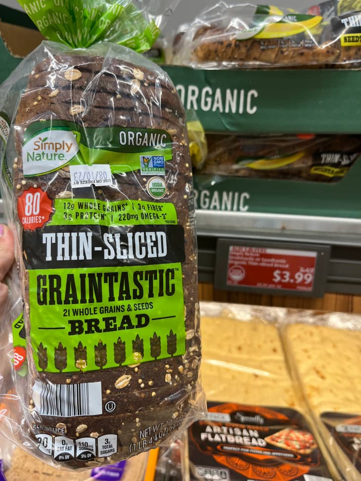 Someoe holding package of sliced bread.