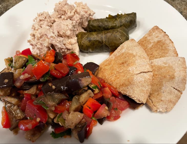 eggplant salad and cold chicken with walnut sauce, stuffed grape leaves, tabouleh, pita