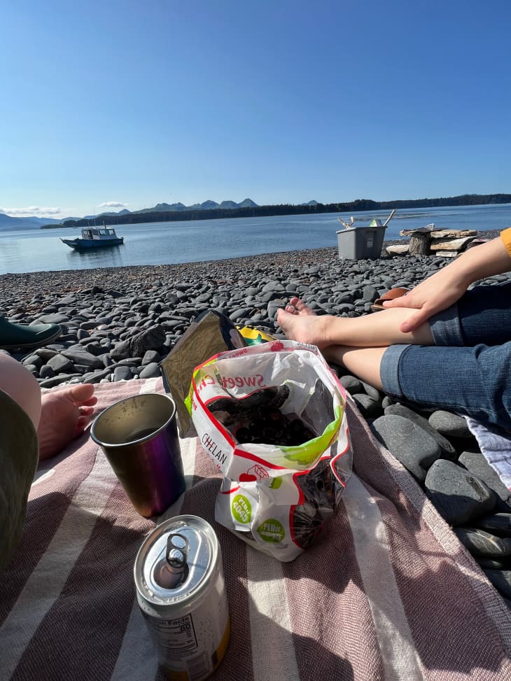 People sitting on the beach eating snacks and drinking cocktails.