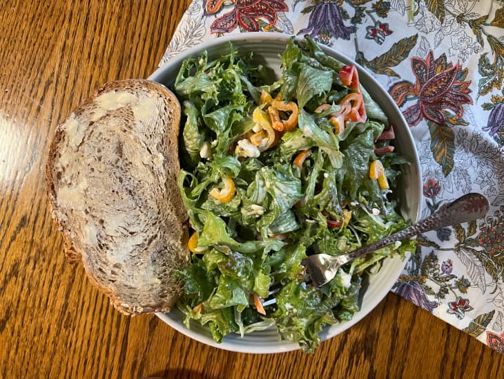 Salad sliced peppers and buttered bread on the side.