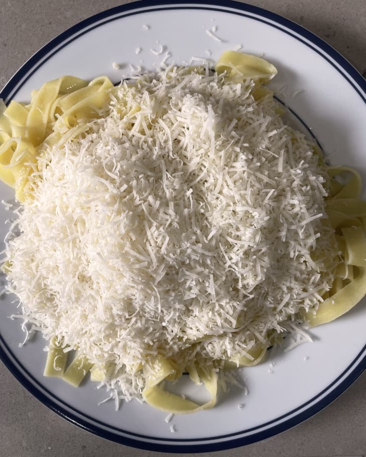 fettucine with grated cheese for alfredo on a plate