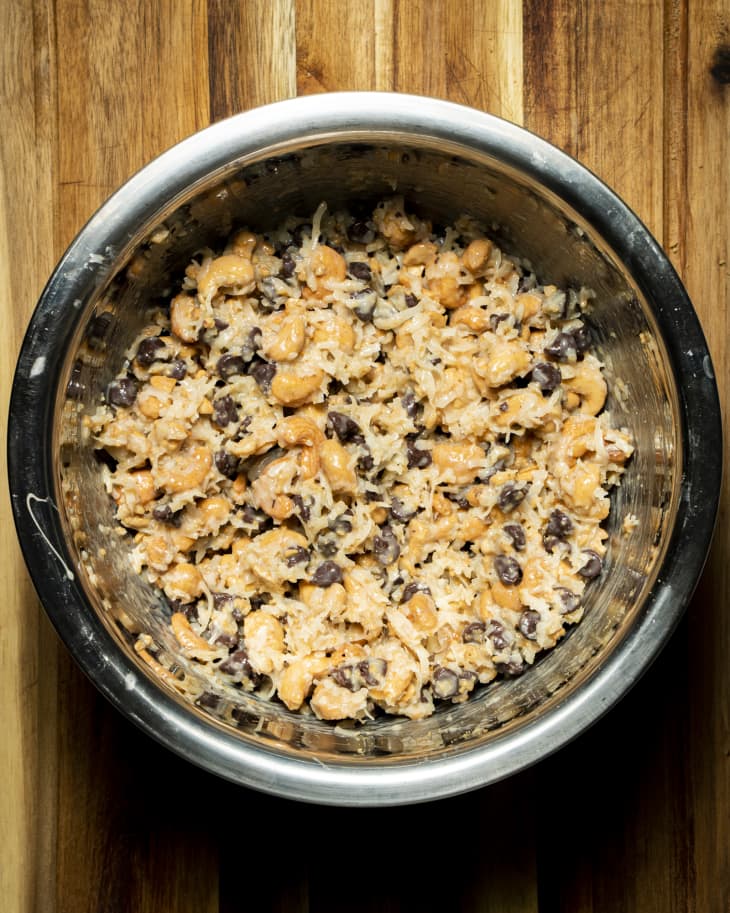 bowl of ingredients blended together, chunky dough in stainless steel bowl