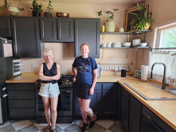 Two dwellers take a photo in a kitchen.