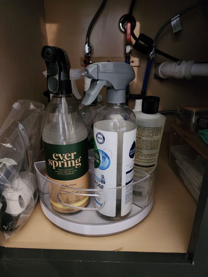 turnstile clear tray with cleaning spray bottles under sink, storage