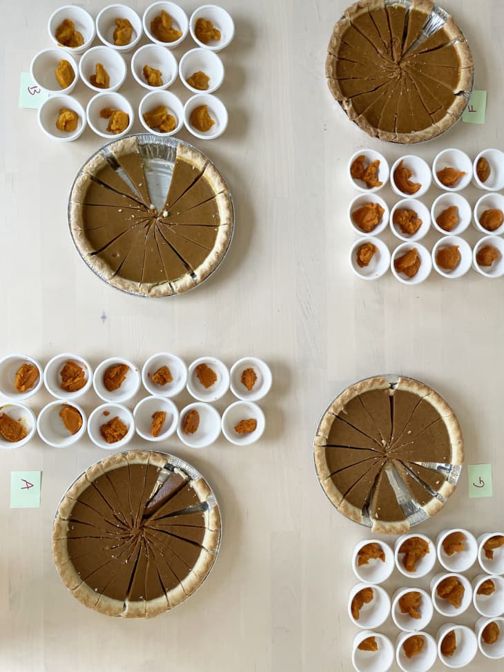 pumpkin pies that have small slivers cut out along with small paper cups filled with different pumpkin fillings for tasting