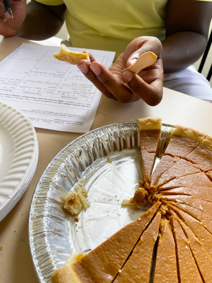a tester is trying a sample of a cut up pie with a score sheet in front of them
